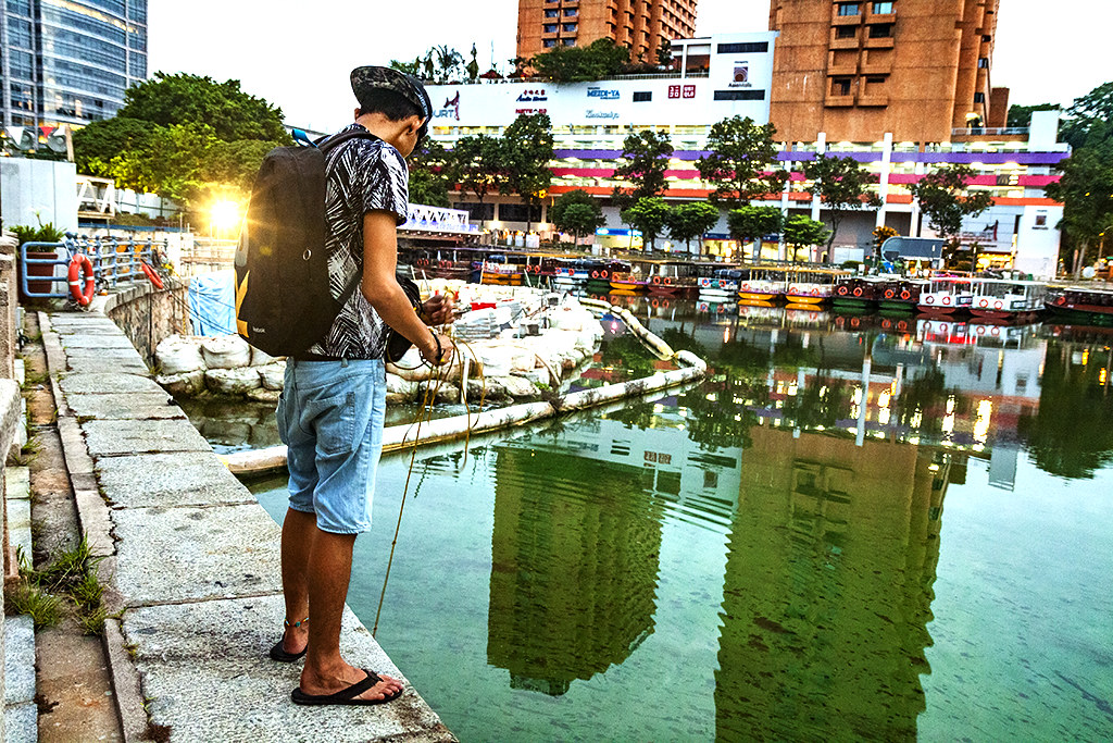 Man catching tiny fish--Singapore