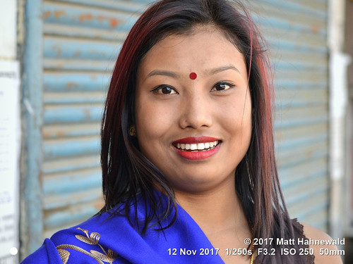 matthahnewaldphotography facingtheworld character head face forehead bindi makeup eyes catchlights teeth lips longhair fashion sari blue fun travel lifestyle enjoyment beauty cultural hinduism bazaar imphal manipur northeast india hindu indian asian asia female young woman lipstick nikond3100 primelens 50mm street portrait outdoor posing authentic smiling laughing beautiful cheerful joyous curvaceous voluptuous smilingeyes fullfigured expression headshot nikkorafs50mmf18g fullfaceview colour person emotional closeup consensual lookingatcamera clarity plump