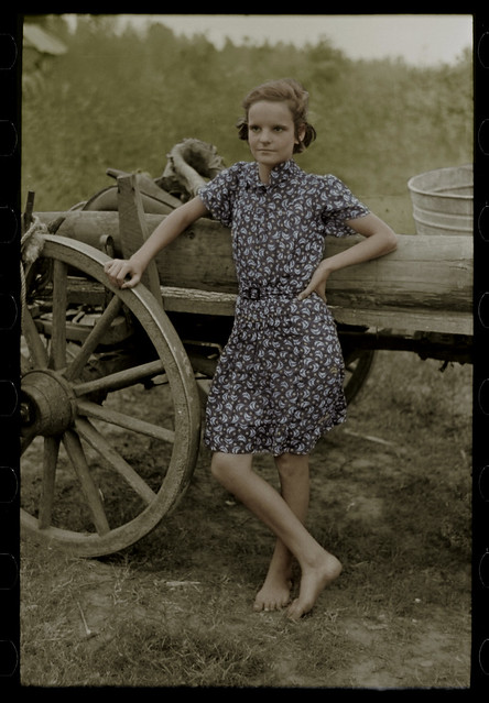 Stepping out of time Farm girl leaning on wagon