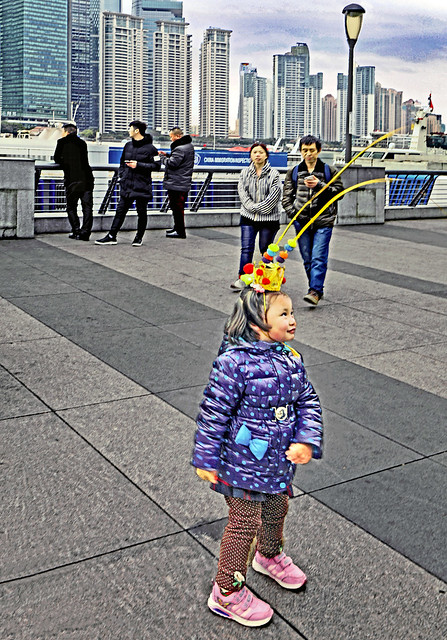 China. February 2017. Shanghai. The Bund. Little girl with Monkey Year symbol in her hair.
