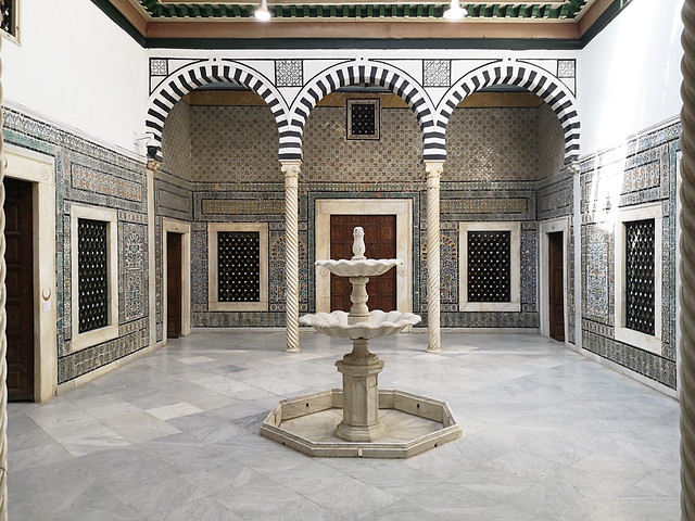 Patio interior fuente tres arcos y paredes de azulejo Museo Nacional del Bardo Tunez