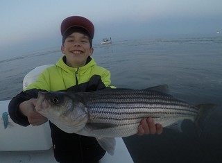 Photo of boy holding a nice striped bass he caught and released
