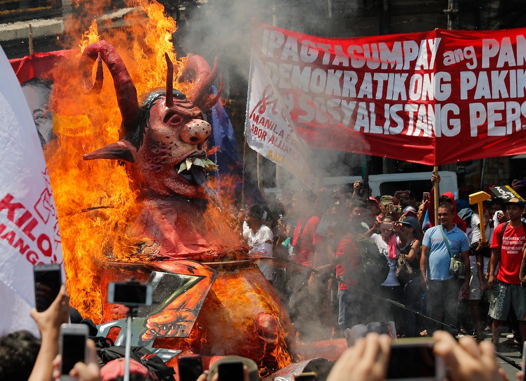 菲律賓五一遊行焚燒杜特蒂巨型肖像。遊行訴求包括：提高最低工資與延長產假。（圖片來源：Mark Cristino/EPA）
