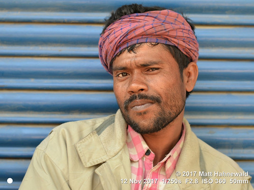matthahnewaldphotography facingtheworld character head tiltedhead face eyes scrutinizingeyes questioningeyes beard frenchbeard stubble bandana lifestyle cultural roadside labourer migrant imphal urban manipur northeast india asia indian asian male man backdrop nikond3100 50mm street portrait checkered outdoor photoshop editing softfocus posing authentic friendly manly pink headwrap postprocessing expression headshot nikkorafs50mmf18g threequarterview posingcamera colour person closeup consensual middleaged lookingatcamera clarity