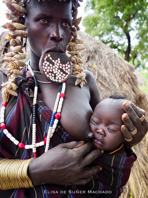 Woman with her baby / Mursi Tribe / Mago National Park / Lip plates are worn by mostly women to signify their status / The plate in the mouth it’s symbol of pride and identity / October 2017