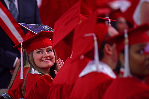 Student waves to family after entering PNC Arena for commencement.