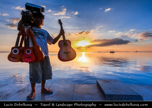 Philippines - Manila - Silhouette of Guitar Seller on Shores of Manila Bay at Sunset Time