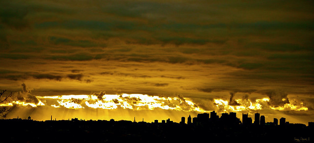 Wall cloud hangs over Boston, in silhouette at sunrise.