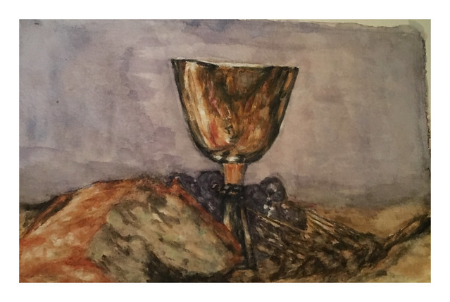 A goblet, bread and a bunch of grapes