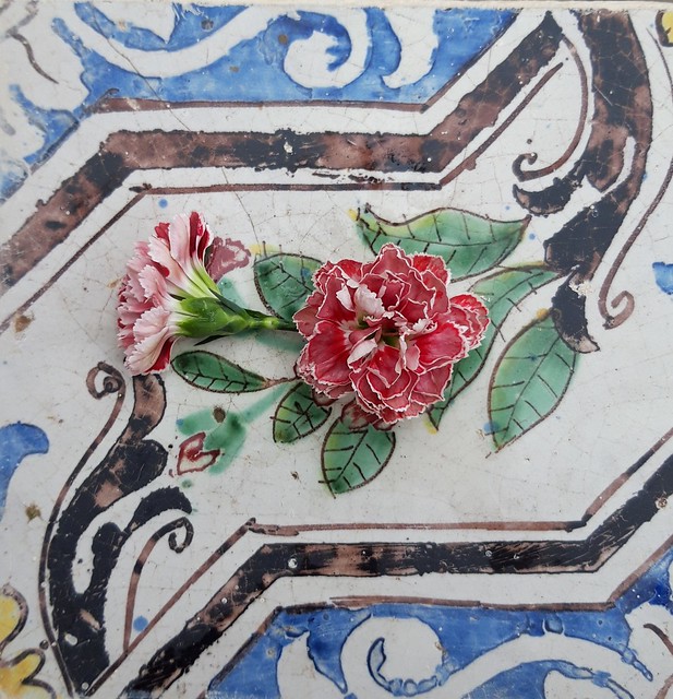 Small carnations on sicilian ceramic tile