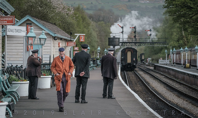 Station crew watches the morning Whitby train depart Grosmont--engine shed man has a broad grin having sent 