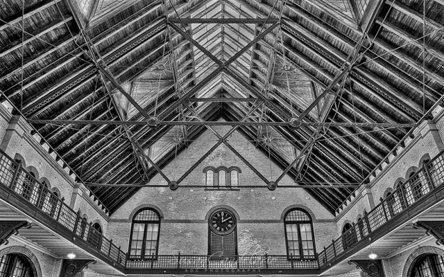Timeless BWCRRNJ Terminal Station - CRRNJ Terminal Station. View of the interior symmetrical structure of the terminal station with vintage clock. From this terminal building commuters and tourist board the ferry to the iconic landmark of Ellis Island, in