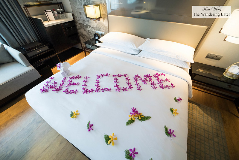 King sized bed with 'welcome' written with fresh flowers