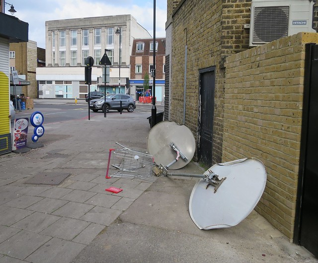 Satellite dishes and broken supermarket trolley dumped in alley St Loy's Road