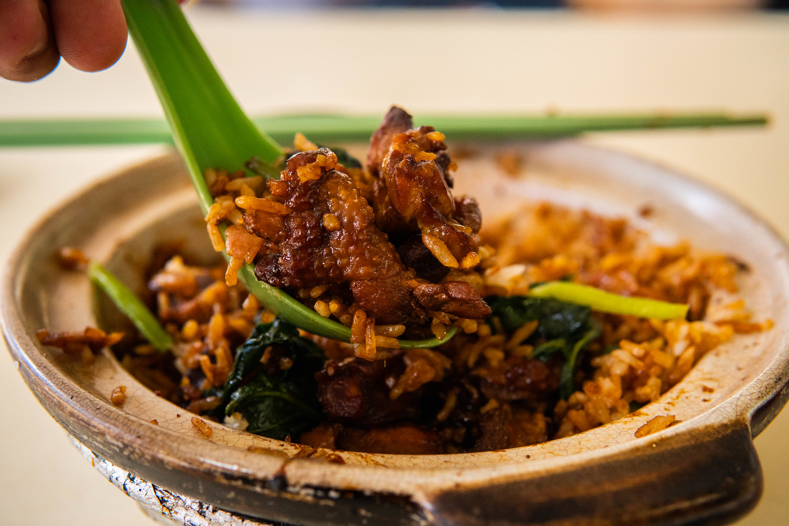 A spoonful of rice and chicken from a claypot