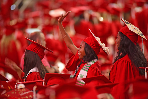 Student waves to family after entering PNC Arena for commencement.