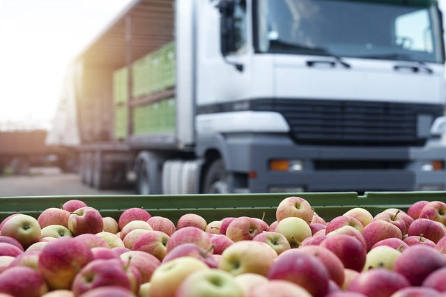 Truck with containers of apples and tray of apples in front of the truck