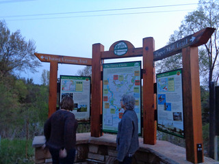 Anna and Barb at a Green Circle trail sign next to the bridge over the river.