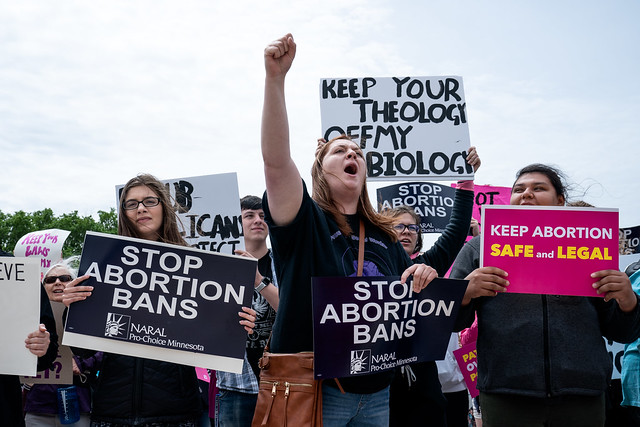 Keep Your Theology Off My Biology and other abortion rights signs at a Stop Abortion Bans Rally in St Paul, Minnesota, May 22, 2019