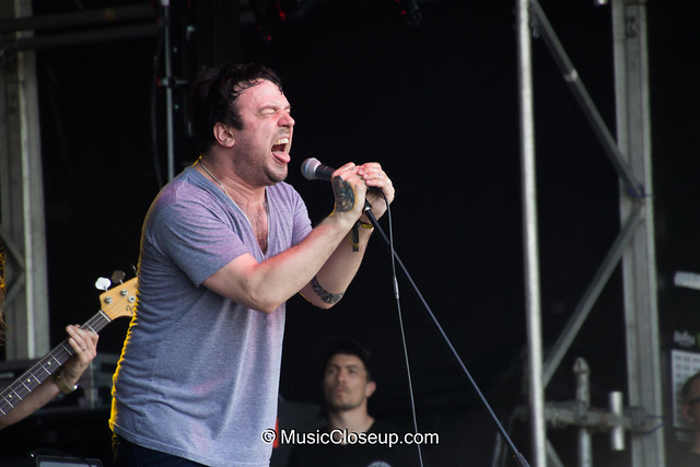The singer of Say Anything singing passionately with his eyes closed and tongue out