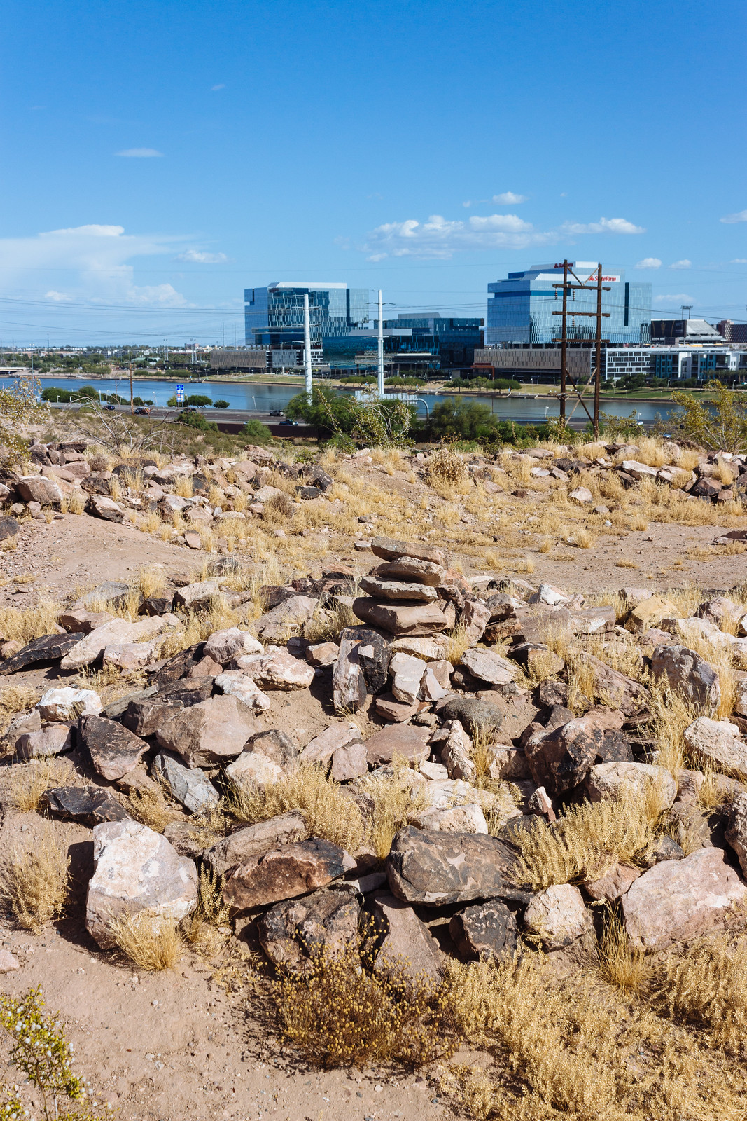 Stone ruins overlooking a lake and glassy office buildings in Tempe, Arizona