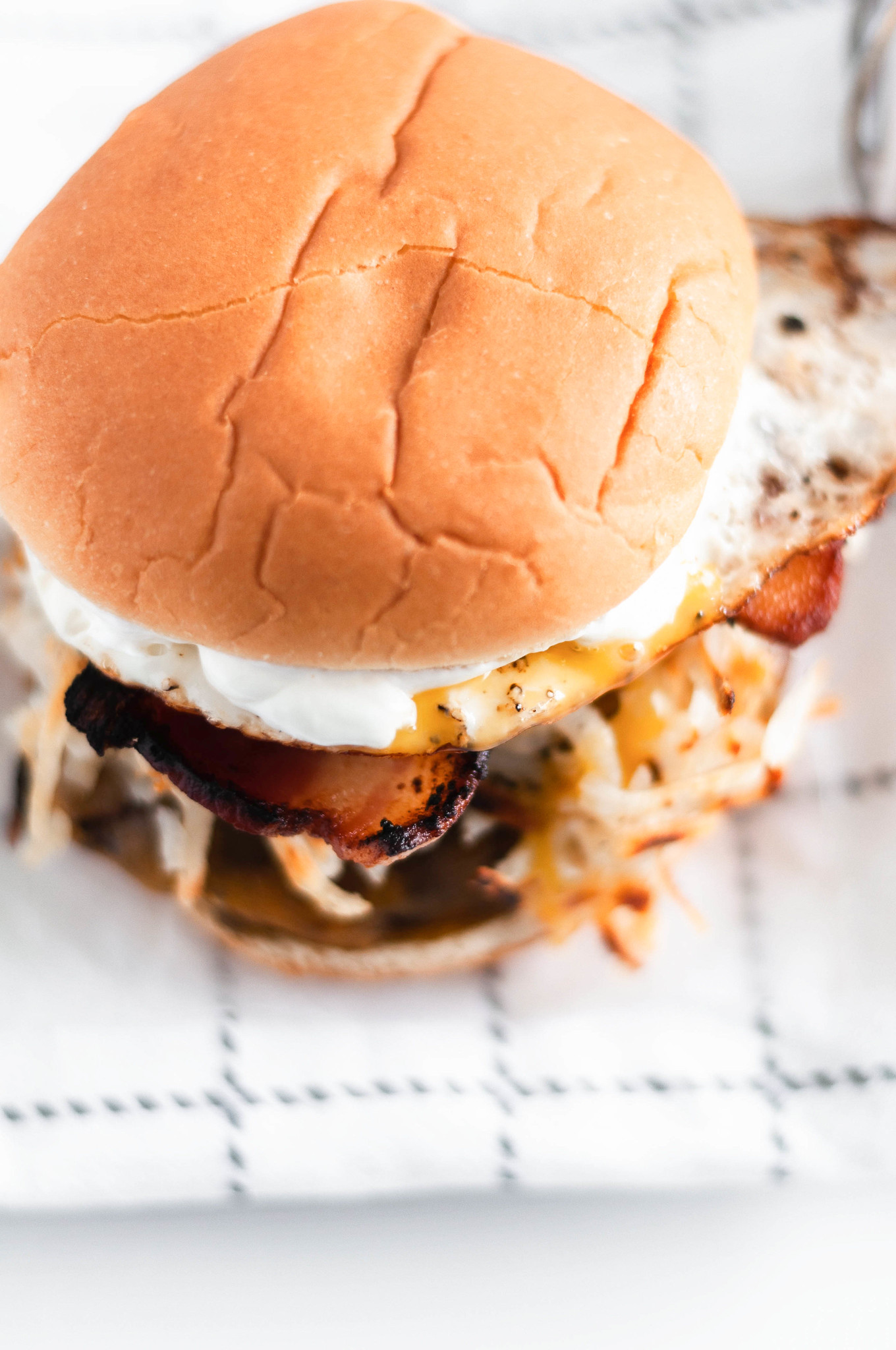 Make these Loaded Breakfast Burgers for dad this Father's Day. Juicy burgers topped with all the breakfast essentials, crispy hash browns, smoky bacon, drippy eggs and sharp cheddar cheese.