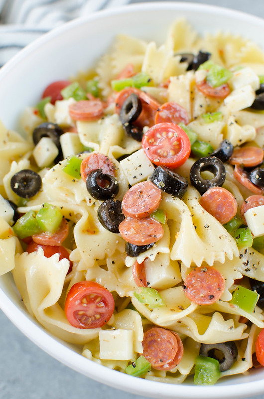 Pepperoni Pizza Pasta Salad - the perfect side dish for all your summer barbecues! Pasta tossed with mini pepperoni, black olives, green bell pepper, tomatoes, mozzarella cheese, and Italian dressing. 