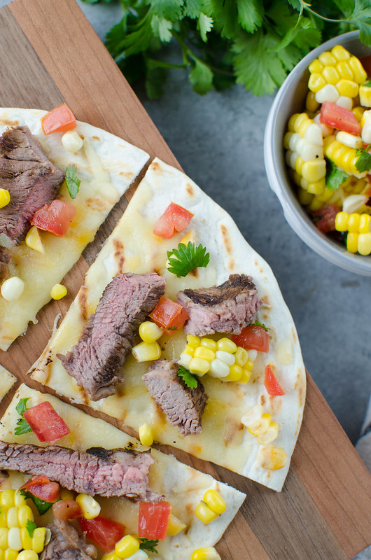 Grilled Tequila Steak Pizza - steak marinated in tequila, lime juice, and chipotle peppers and grilled to perfection. Layered on a grilled flour tortilla with cheese and a delicious corn and tomato topping. Easy and quick enough for a weeknight dinner! 