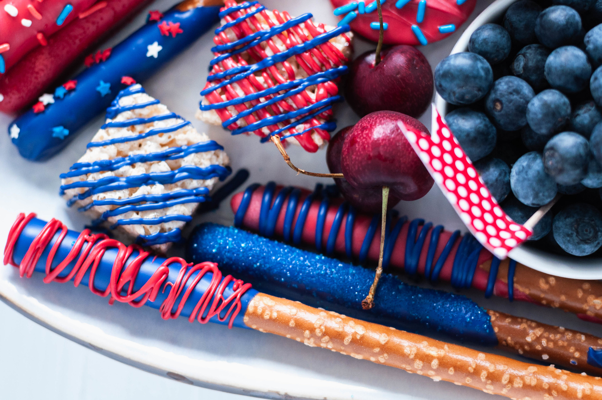 You'll be the hit of the 4th of July party when you show up with this Red White and Blue Dessert Board. Super simple to make with store-bought ingredients, some time and all your creative juices.