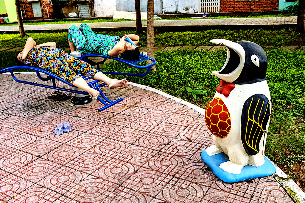 Two middle aged women and a penguin trash can--Saigon