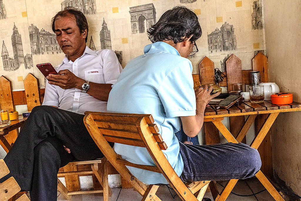 Two men at Goc Nho Cafe looking at cellphones--Saigon