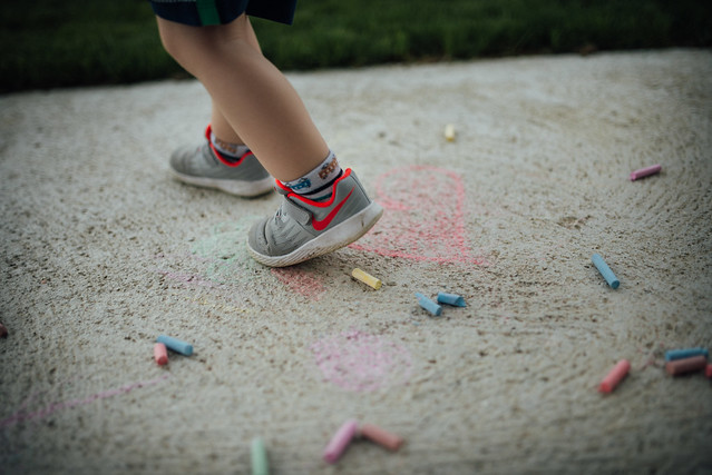 A boy stepping on colored chalk