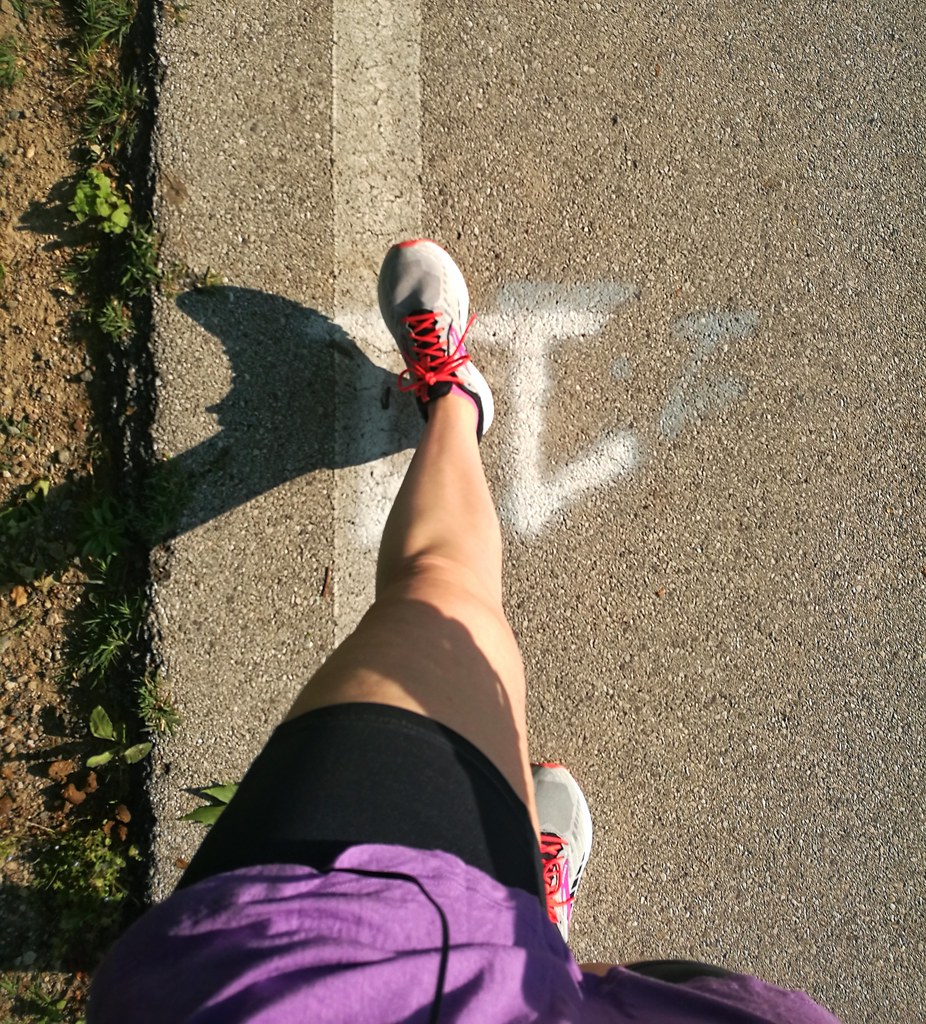 A woman's legs in running trainers on asphalt