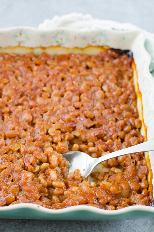 Pineapple Baked Beans - a favorite side dish for BBQs! Beans with bacon, crushed pineapple, and brown sugar are baked until the sauce is thick and delicious.