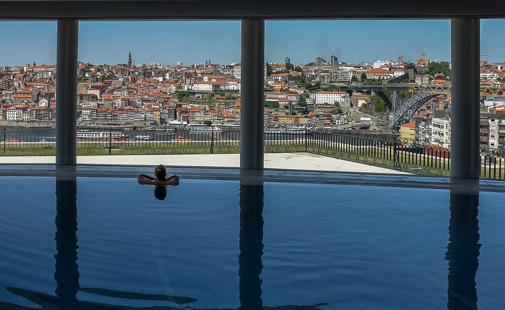 Person resting in spa pool looking at view of Porto, Portugal