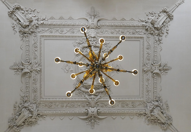 Chandelier hanging from a staircase ceiling medallion