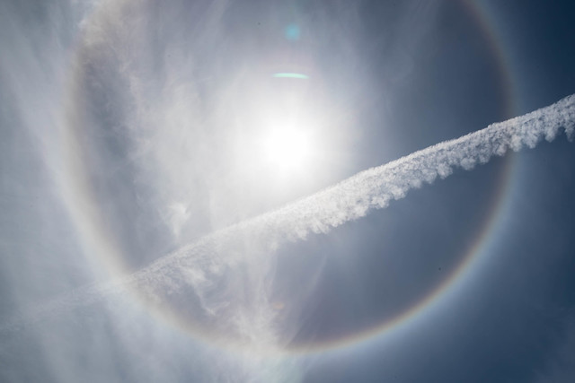 commonly referred to as a 22-degree halo, or a sun halo.  A 22-degree halo is created by tiny ice crystals in high cirrostratus clouds. The sunlight refracts through the ice at a 22 degree angle, creating the halo effect.