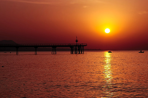 sea seascape water sky cielo skyscape skyline clouds pier bridge pont puente construction mountain reflection backlight contraluz color colour colores colours colors shadow shadows sun sol sole sunrise salidadelsol amanecer dawn boat motorboat people outside outdoor