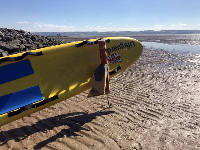 Lifesaving surfboard at the beach by a low tide, free to use beach stock photo