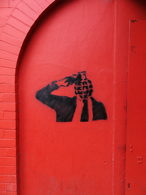 Spray art of a grenade head on a red wall in Belfast, Ireland