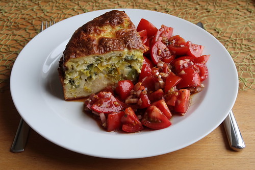Stück von Lauchquiche (aufgetaut und aufgebacken) mit Tomatensalat