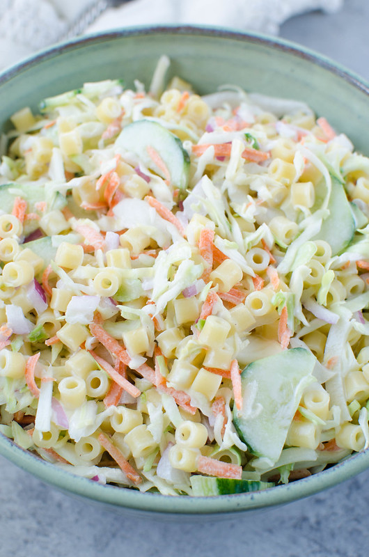 Cole Slaw Pasta Salad - two delicious side dishes in one! Pasta, cole slaw mix, red onion, and sliced cucumber in a creamy sweet and tangy dressing. Perfect for barbecues and potlucks!
