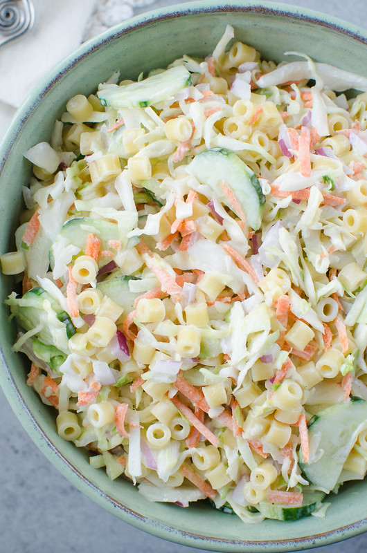 Cole Slaw Pasta Salad - two delicious side dishes in one! Pasta, cole slaw mix, red onion, and sliced cucumber in a creamy sweet and tangy dressing. Perfect for barbecues and potlucks!