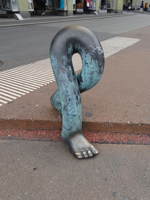 escultura de bronce dos piernas bajando la acera obra de Luciano Andreani Berna Suiza