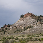 20190729-OSEC-LSC-0208 Tree topped ridges and multi-colored outcroppings in U.S. Department of Agriculture (USDA) Forest Service (FS) Thunder Basin National Grassland, along Highway 450, in Northeast  Wyoming, on July 29, 2019. 
The Thunder Basin National Grassland is located in northeastern Wyoming in the Powder River Basin between the Big Horn Mountains and the Black Hills. Elevation on the national grassland ranges from 3,600 to 5,200 feet, and the climate is semi-arid. The national grassland provides unique opportunities for recreation, including hiking, sightseeing, hunting, and fishing. There are no developed campgrounds; however, dispersed camping is allowed. The national grassland abounds with wildlife year-round, provides forage for livestock, and is underlain with vast mineral resources. Land patterns are very complex because federal, state, and private lands are intermingled. The Douglas Ranger District administers the Thunder Basin National Grassland. USDA Photo by Lance Cheung. 