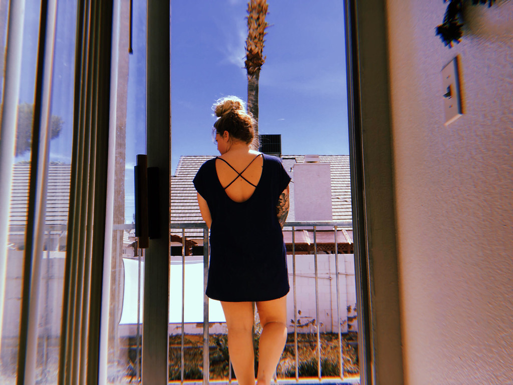 Frau steht auf ihrem Balkon und lauscht