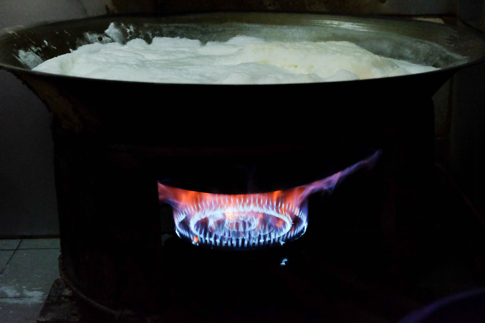 Boiling the soya bean milk in a wok to make tau huey
