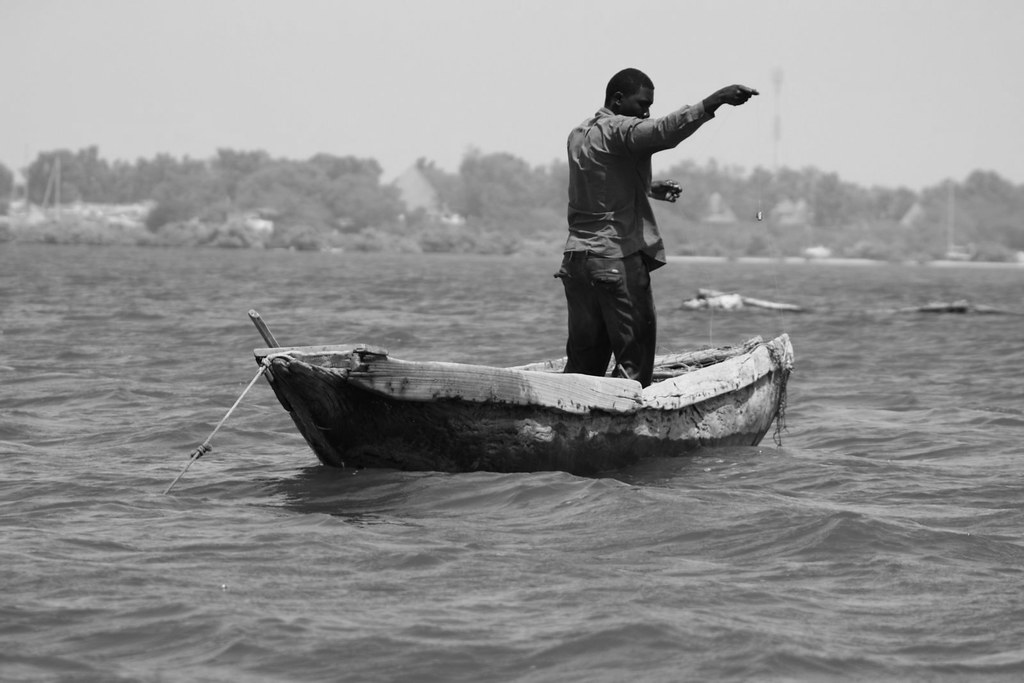 fisherman standing on his small boat