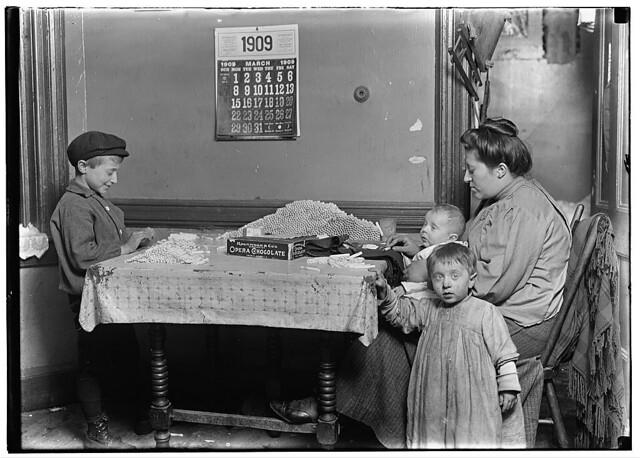Widow & boy rolling papers for cigarettes in a dirty N.Y. tenement. (LOC)