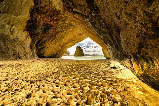 The golden sands inside the archway at Coromandel Cove in the Coromandel